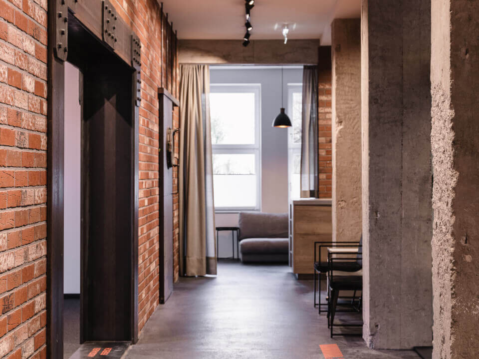 Modernes Interieur mit Backsteinwand, Lichtschienen und stylischer Raumaufteilung.