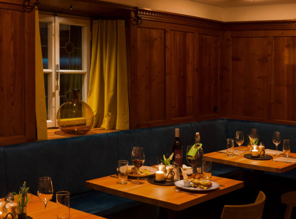 Gemütliches Restaurant mit warmer Beleuchtung und ansprechend gedeckten Tischen.