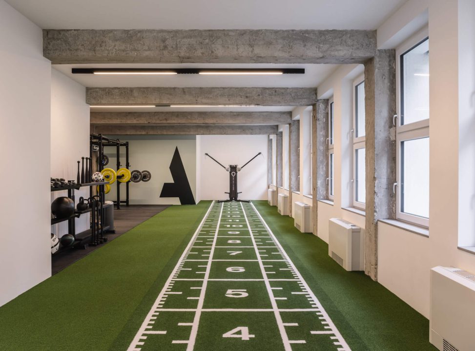 Moderne Trainingsfläche mit grüner Teppichbahn und funktionaler Ausstattung.