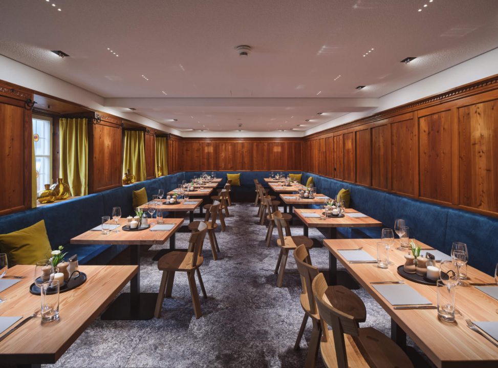 Modern eingerichteter Speisebereich mit Holzvertäfelung und stilvollen Lichtinstallationen.