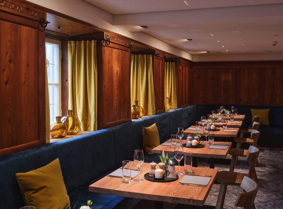 Elegante Innenansicht eines Restaurants mit Holzvertäfelung und stimmungsvoller Beleuchtung.