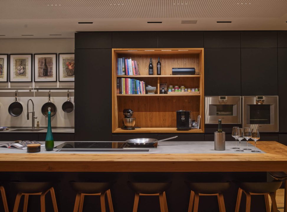 Moderne Küche mit Holztheke, hochwertigen Geräten und stilvoller Beleuchtung.
