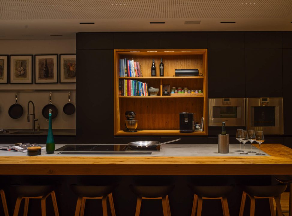 Moderne Küche mit Holzinsel, offenem Regal und stilvoller Beleuchtung. Funktionale Lichtlösung.