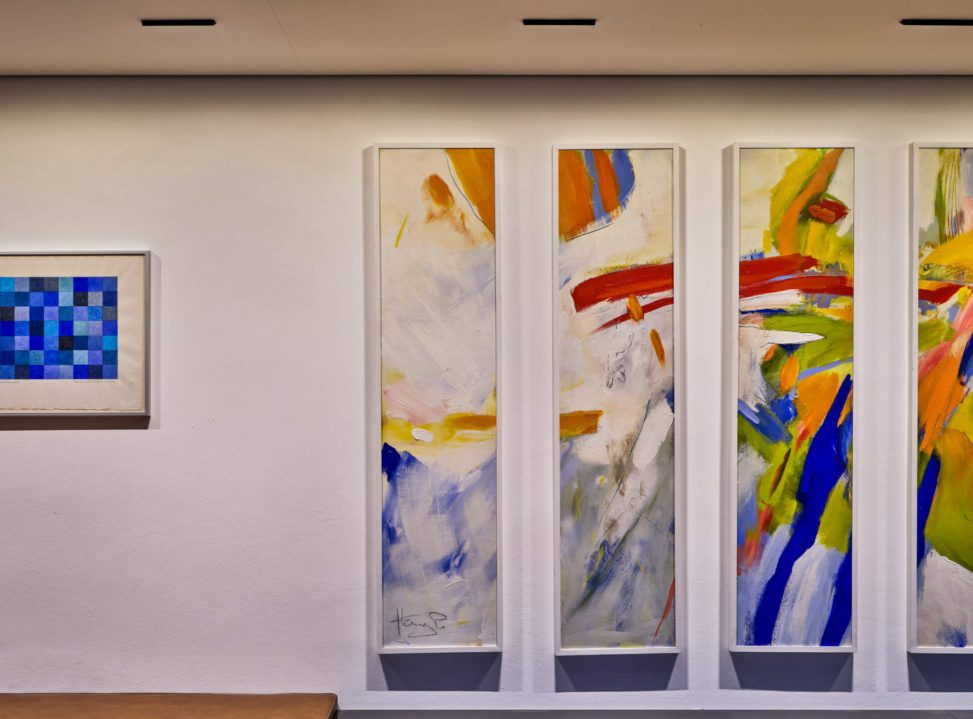 Moderne Kunstwerke an einer hellen Wand, kreative Farbgestaltung und harmonische Komposition.