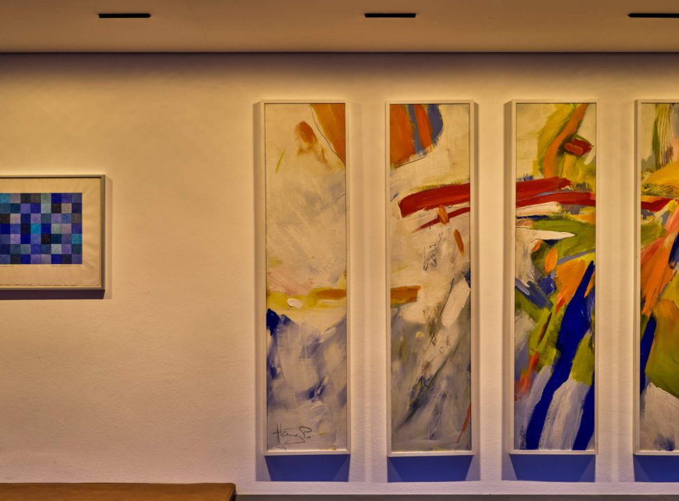 Moderne Wandgestaltung mit bunten Gemälden in einem stilvollen Raum.